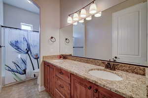 Full bathroom with double vanity, light tile patterned flooring, and shower / bath combination with curtain