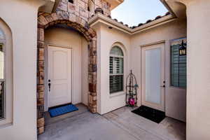 Entrance to property with stone siding and stucco siding