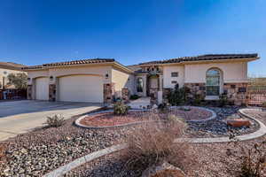 Mediterranean / spanish house with stone siding, stucco siding, driveway, and a garage