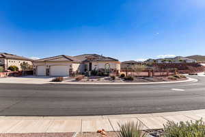 Mediterranean / spanish house with concrete driveway, an attached garage, stone siding, and stucco siding