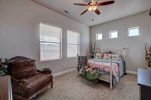 Bedroom with a ceiling fan and light carpet