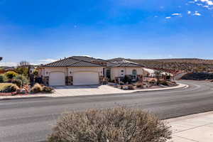 Mediterranean / spanish home featuring stone siding, stucco siding, an attached garage, driveway, and a tile roof