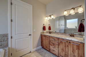 Full bathroom with a garden tub, double vanity, and light tile patterned floors