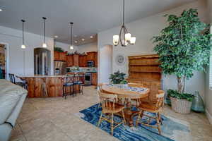 Dining area with arched walkways, a chandelier, and light tile patterned floors
