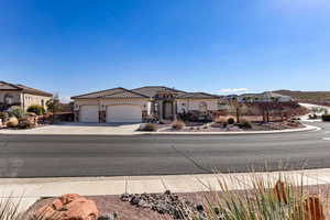 Mediterranean / spanish house featuring stone siding, concrete driveway, an attached garage, a tile roof, and stucco siding