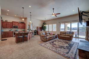 Living area with a ceiling fan, light tile patterned floors, recessed lighting, and a textured ceiling