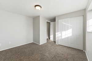 Unfurnished bedroom with carpet and a closet