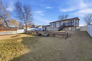 Rear view of house with a fenced backyard and a deck