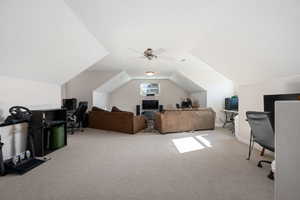 Carpeted office space with lofted ceiling and ceiling fan
