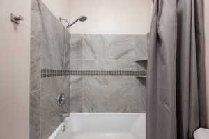 Full bath featuring shower / bath combo with shower curtain
