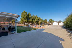 Fenced backyard featuring a patio area, a ceiling fan, and a storage shed