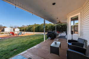 View of patio with grilling area, a ceiling fan, and an outdoor structure