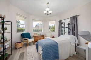 Bedroom featuring wood finished floors and hanging lights