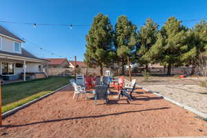 Fenced backyard with a patio, a hot tub, and a fire pit