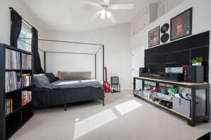 Bedroom featuring carpet flooring, vaulted ceiling, and a ceiling fan