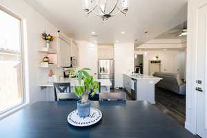 Dining room featuring dark wood-type flooring, a ceiling fan, and hanging lights