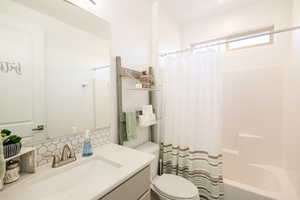 Full bathroom featuring shower / bath combo with shower curtain and vanity