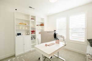 Office area with baseboards and light carpet