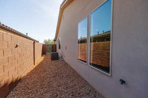 View of side of property with stucco siding and a fenced backyard