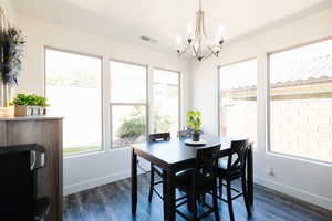 Dining space with dark wood-style floors and hanging lights