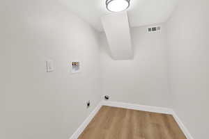 Laundry room featuring light wood finished floors, washer hookup, and electric dryer hookup