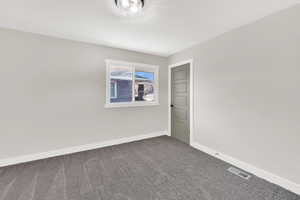 Carpeted empty room featuring baseboards