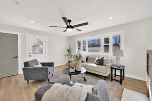 Living area featuring light wood-style flooring, a ceiling fan, and recessed lighting