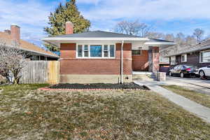 Bungalow-style house with brick siding and a chimney