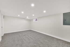 Below grade area featuring recessed lighting, light carpet, and electric panel