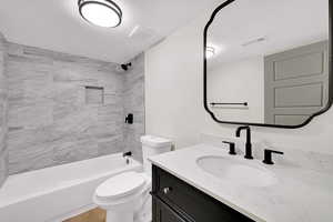 Bathroom featuring vanity, shower / washtub combination, and a textured ceiling