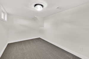 Unfurnished room with carpet and baseboards