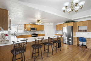 Kitchen with open shelves, stainless steel appliances, tasteful backsplash, a peninsula, and light stone countertops