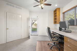Home office featuring a ceiling fan and light carpet