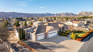 View of front of home with driveway, a mountain view, a residential view, and stucco siding