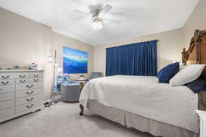 Bedroom with light colored carpet and a ceiling fan