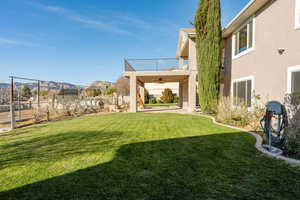 Fenced backyard featuring a ceiling fan and a patio