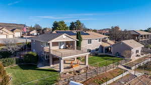 Rear view of house with a fenced backyard, a patio area, solar panels, a residential view, and stucco siding