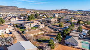 Aerial view of property and surrounding area with a mountainous background and nearby suburban area