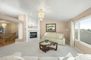 Living room featuring suspended lighting, lofted ceiling, carpet floors, and a premium fireplace