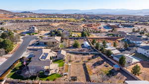Aerial view of property and surrounding area with nearby suburban area and a mountain backdrop