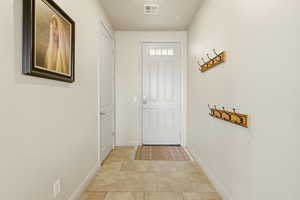 Doorway to outside with tile patterned floors and baseboards