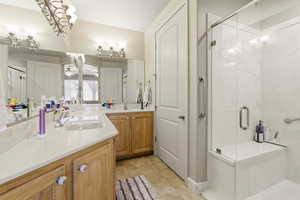 Full bathroom with a stall shower, vanity, and light tile patterned floors
