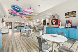 Dining room with ceiling fan, light wood-style flooring, and lofted ceiling
