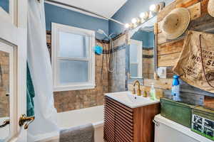 Full bathroom with shower / tub combo and vanity