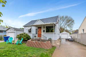View of front of home with roof with shingles, an outbuilding, a detached garage, and concrete driveway