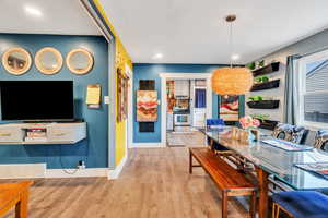 Dining room with light wood-type flooring and a chandelier