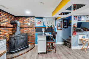 Dining space featuring light wood-style flooring and a wood stove