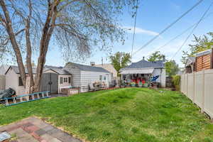 Rear view of house with a storage shed, a fenced backyard, and a patio area
