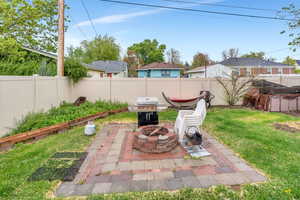 Fenced backyard featuring a patio area and a fire pit