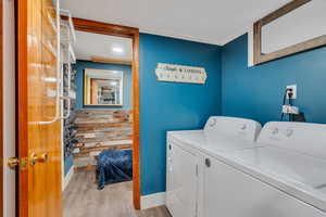 Laundry area with light wood-style floors and washing machine and dryer